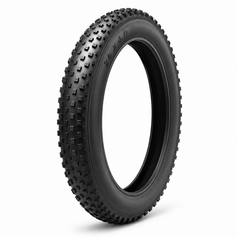 Off-road bicycle tire with chunky knobby tread standing upright; size 26x4.0 visible on sidewall.
